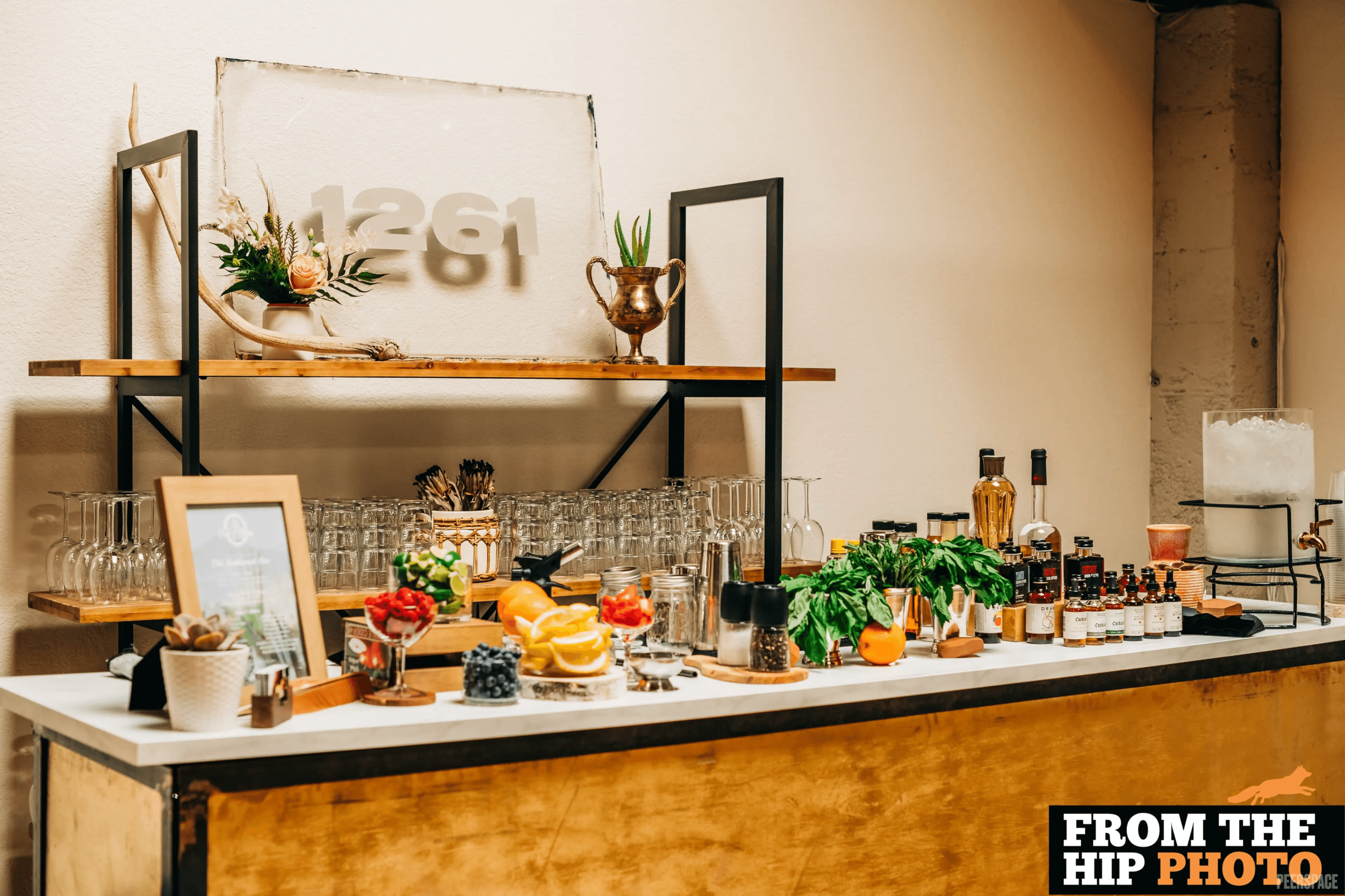 Sterling Event Space bar setup with charcuterie, glassware, and the 1261 sign backdrop