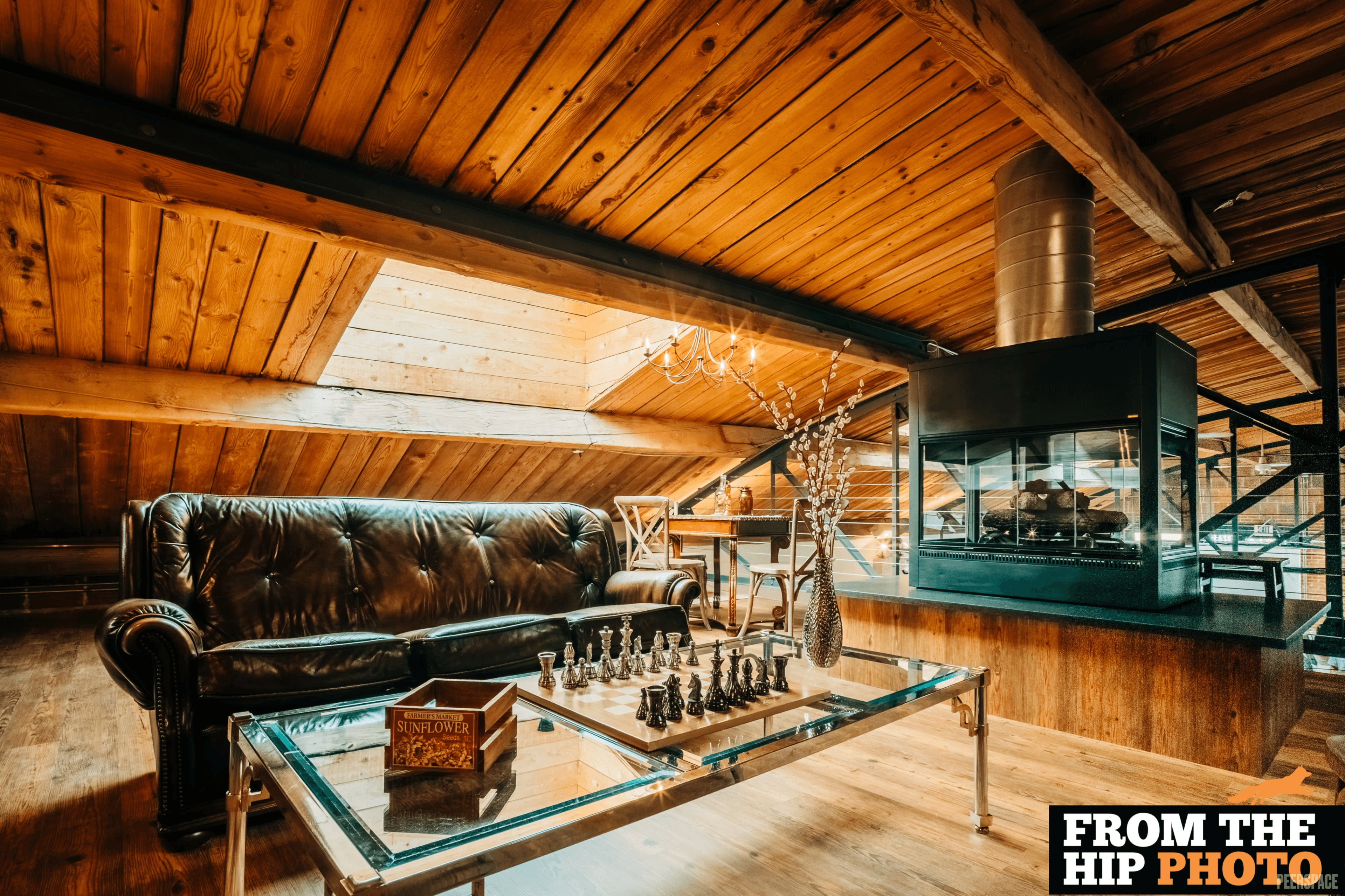 The Sterling loft — leather chesterfield, glass chess table, and gas-lit fireplace