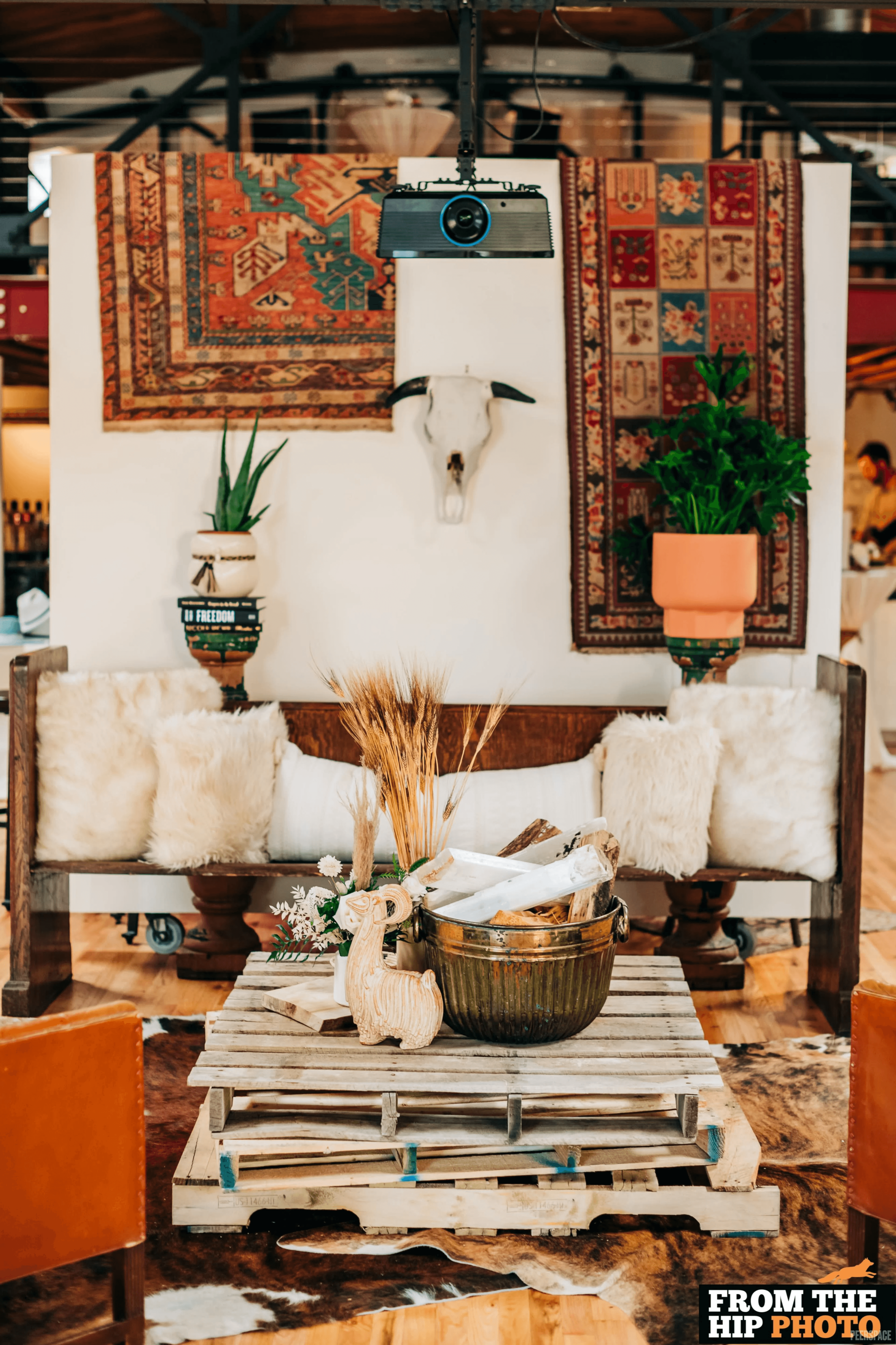 Styled production set inside Sterling Event Space — Persian rugs, sheepskin, pallet table